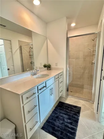 a bathroom with a sink a toilet a mirror and shower