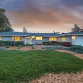 a front view of a house with yard and green space