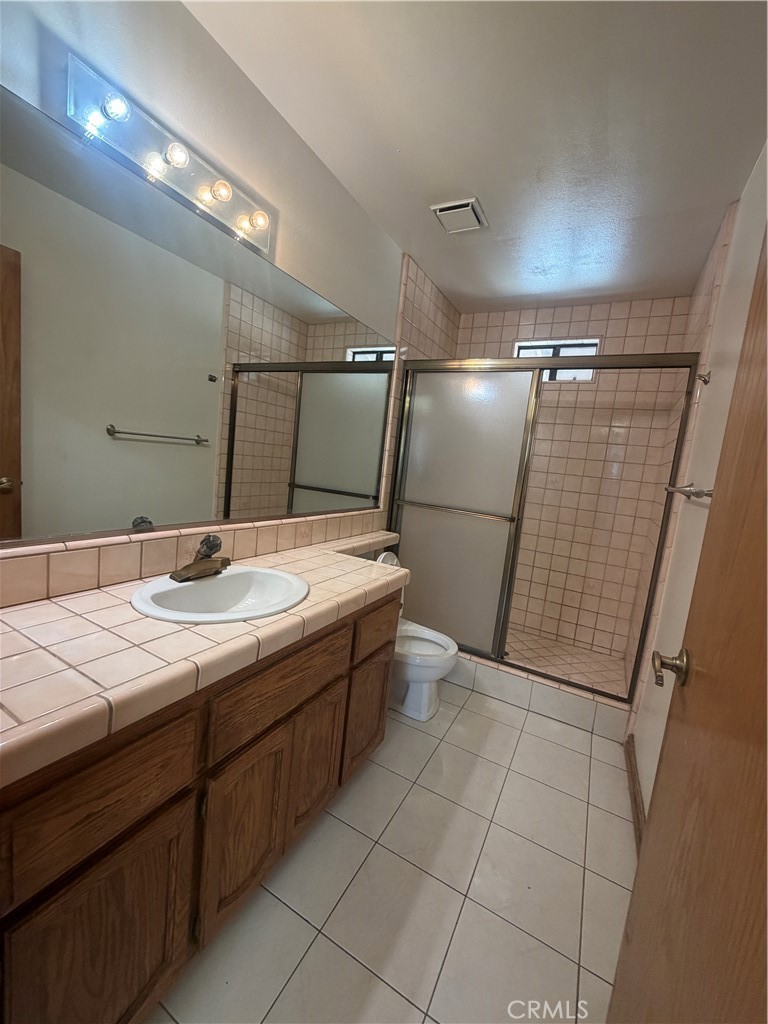 19609 Seneca Road Apple Valley, CA 92307 - Photo 16 of 37 a bathroom with a sink a mirror and shower