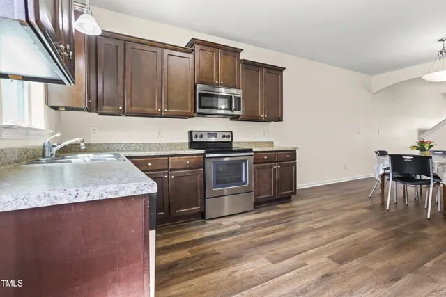 a kitchen with stainless steel appliances granite countertop a sink stove microwave and cabinets