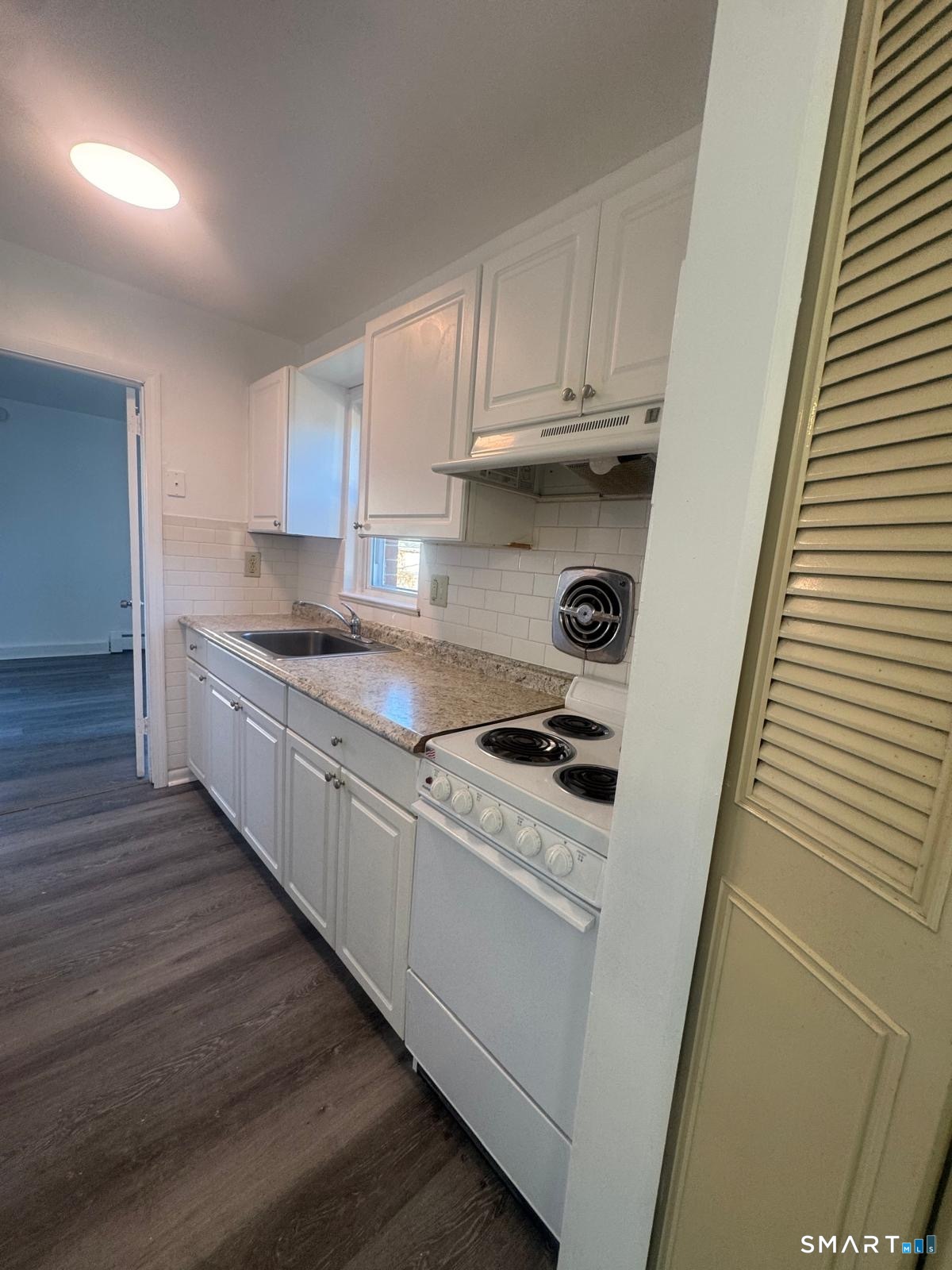 190 Birdseye Street, Unit A9 Bridgeport, CT 06604 - Photo 1 of 8 a kitchen with granite countertop wood cabinets and white appliances