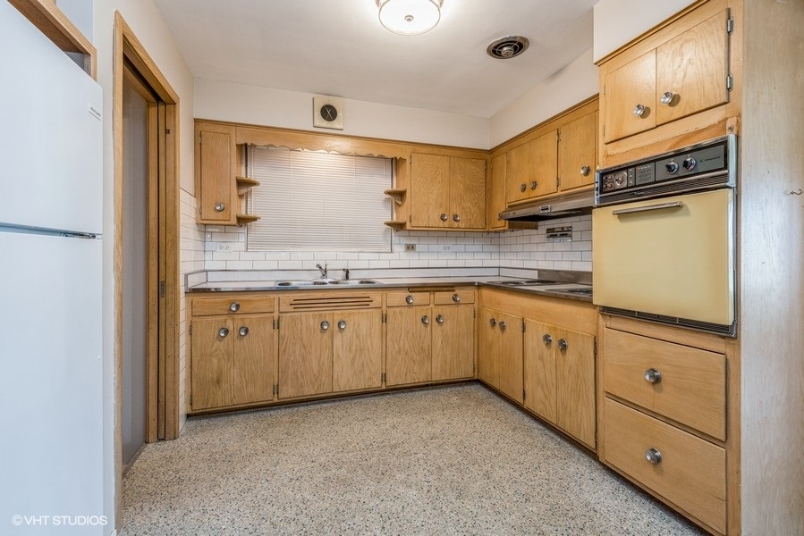 7045 West Madison Street Niles, IL 60714 - Photo 4 of 22 a kitchen with cabinets oven and a dishwasher with wooden floor