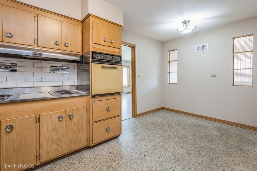 7045 West Madison Street Niles, IL 60714 - Photo 6 of 22 a kitchen with granite countertop cabinets and window