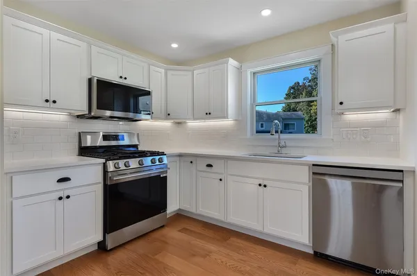 a kitchen with stainless steel appliances granite countertop a sink and a stove