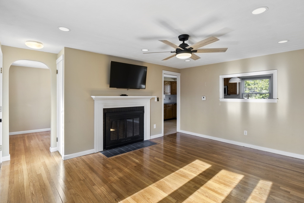 165 Sawmill Road Springfield, MA 01118 - Photo 19 of 39 a view of a livingroom with a fireplace a ceiling fan and wooden floor