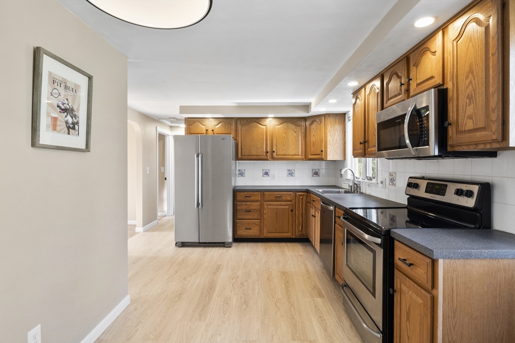 165 Sawmill Road Springfield, MA 01118 - Photo 23 of 39 a kitchen with stainless steel appliances granite countertop a stove a sink dishwasher and a refrigerator with wooden floor