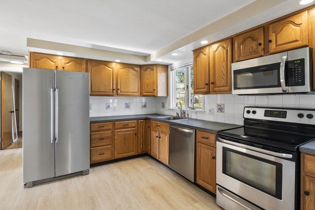 165 Sawmill Road Springfield, MA 01118 - Photo 24 of 39 a kitchen with stainless steel appliances granite countertop a stove a sink and a refrigerator