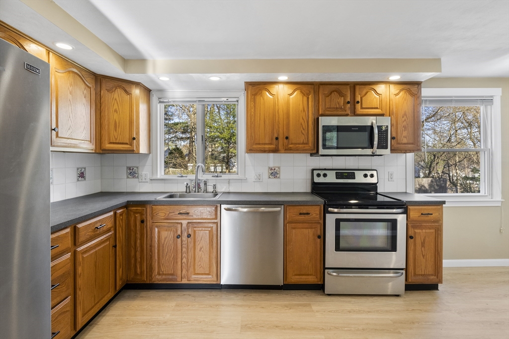 165 Sawmill Road Springfield, MA 01118 - Photo 25 of 39 a kitchen with stainless steel appliances granite countertop a stove a sink and a microwave