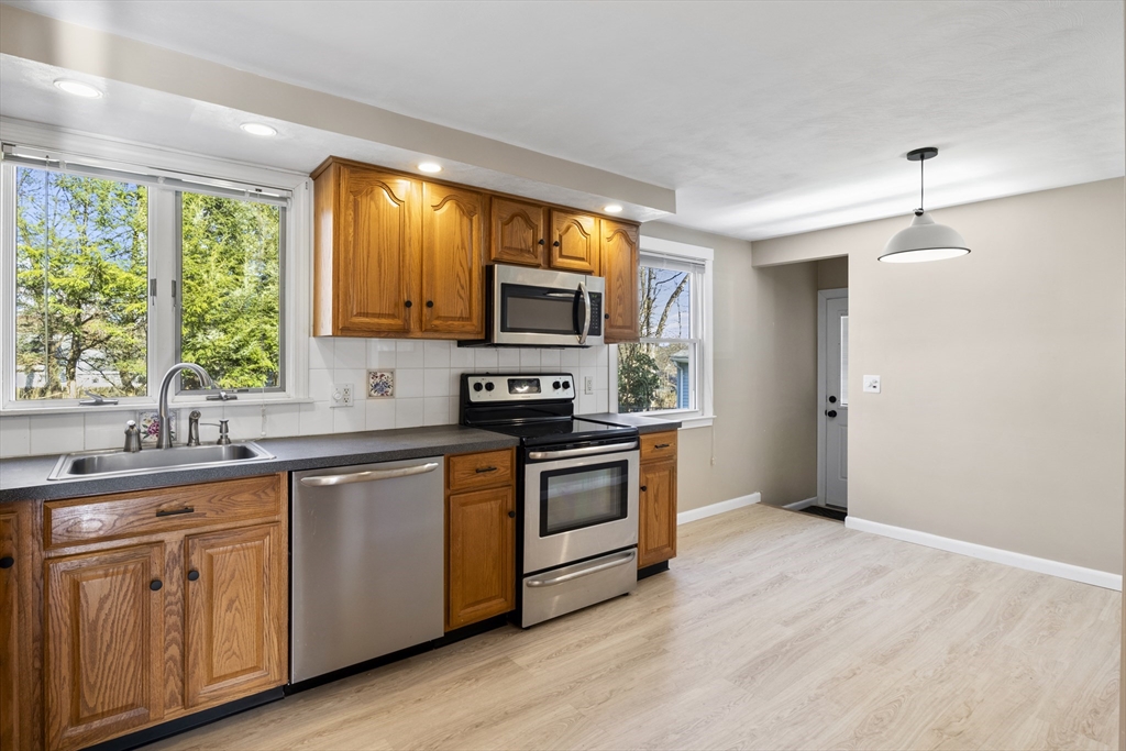 165 Sawmill Road Springfield, MA 01118 - Photo 26 of 39 a kitchen with stainless steel appliances granite countertop a stove a sink and a microwave