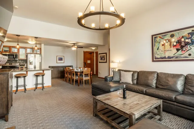 a living room with furniture a dining table and a chandelier