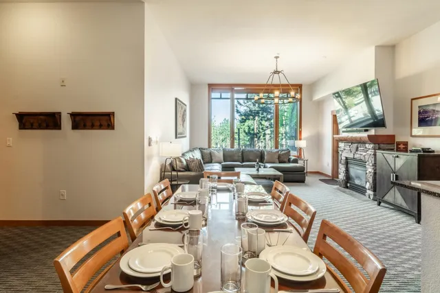 a dining room with furniture a large window and wooden floor