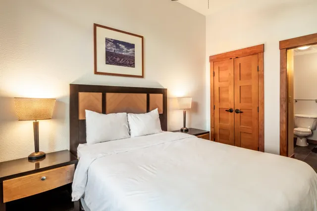 a bedroom with a bed and a lamp on table