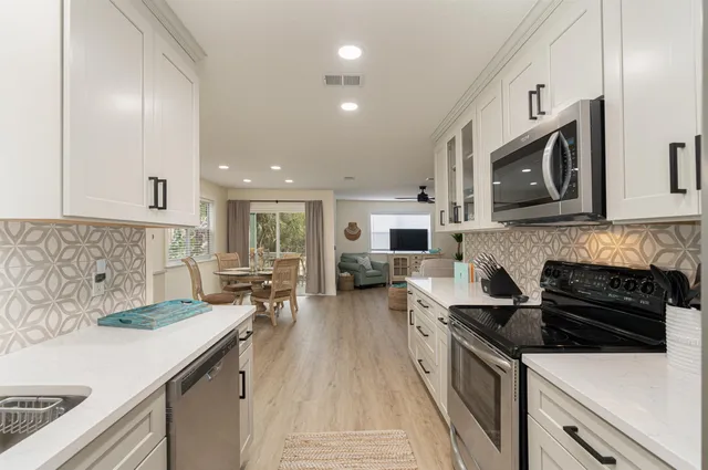 a kitchen with stainless steel appliances a stove sink microwave and cabinets