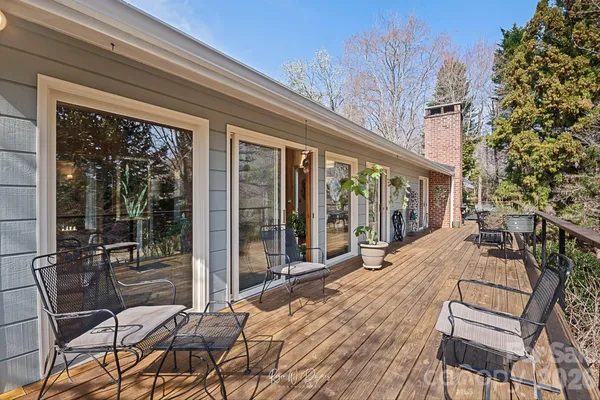 a view of a patio with table and chairs potted plants with floor to ceiling window