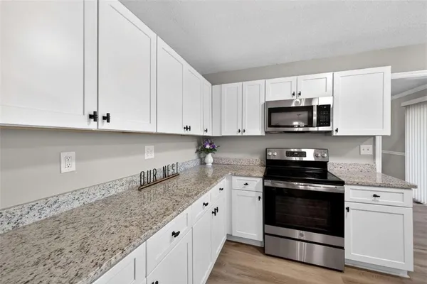a kitchen with stainless steel appliances granite countertop a stove a sink and a microwave