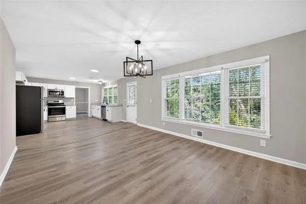 a view of empty room with wooden floor and window