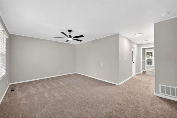 a view of a livingroom with a ceiling fan and window