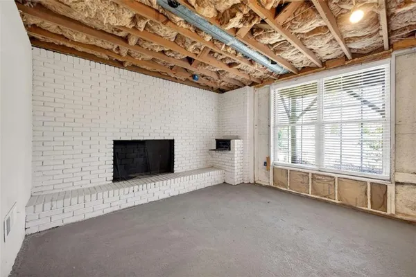 a view of an empty room with a fireplace and a window