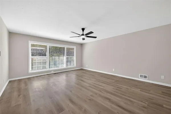 a view of a livingroom with wooden floor and a ceiling fan