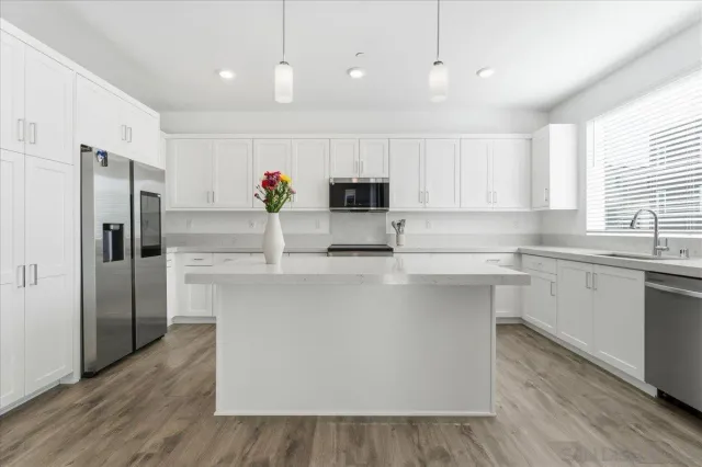 a kitchen with kitchen island white cabinets and stainless steel appliances