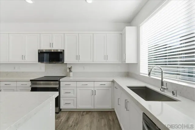 a kitchen with granite countertop white cabinets and white appliances