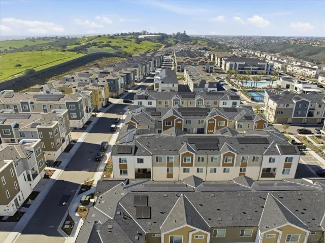 an aerial view of residential houses with outdoor space and ocean view