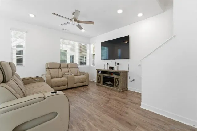 a living room with furniture a flat screen tv and kitchen view