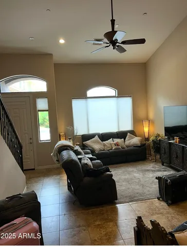 a living room with furniture and a ceiling fan