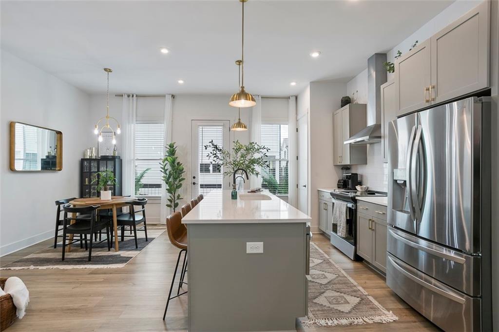 1081 Crest Circle Southeast Atlanta, GA 30312 - Photo 3 of 26 a kitchen with stainless steel appliances granite countertop a refrigerator a stove a sink a dining table and chairs with wooden floor