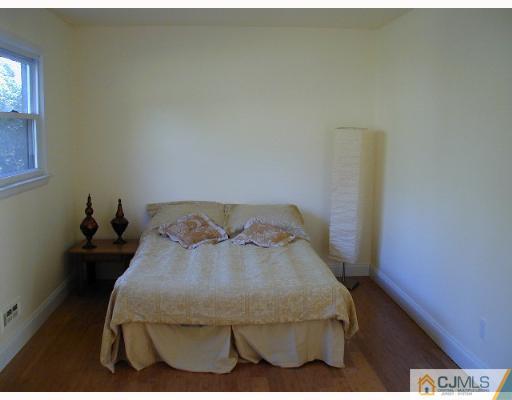 33 Allwood Road East Brunswick, NJ 08816 - Photo 4 of 8 a bed sitting in a bedroom next to a window