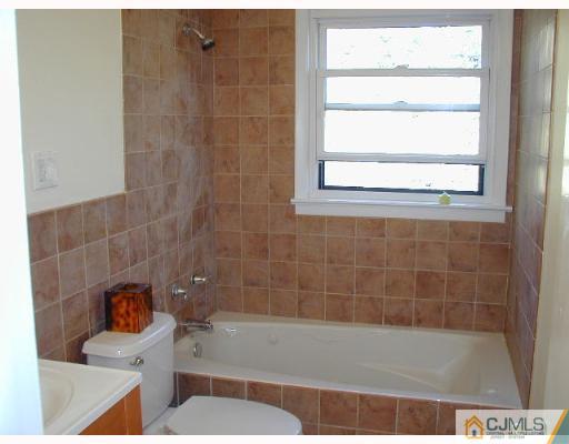 33 Allwood Road East Brunswick, NJ 08816 - Photo 7 of 8 a bath tub sitting next to a blue sink and a toilet