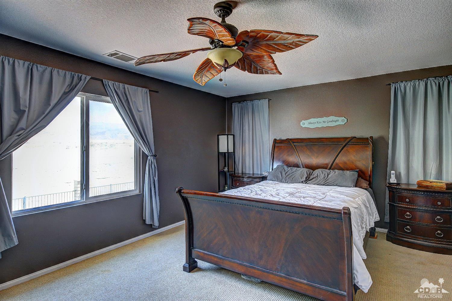 82734 Mount Riley Drive Indio, CA 92203 - Photo 15 of 26 a bedroom with a bed and a ceiling fan