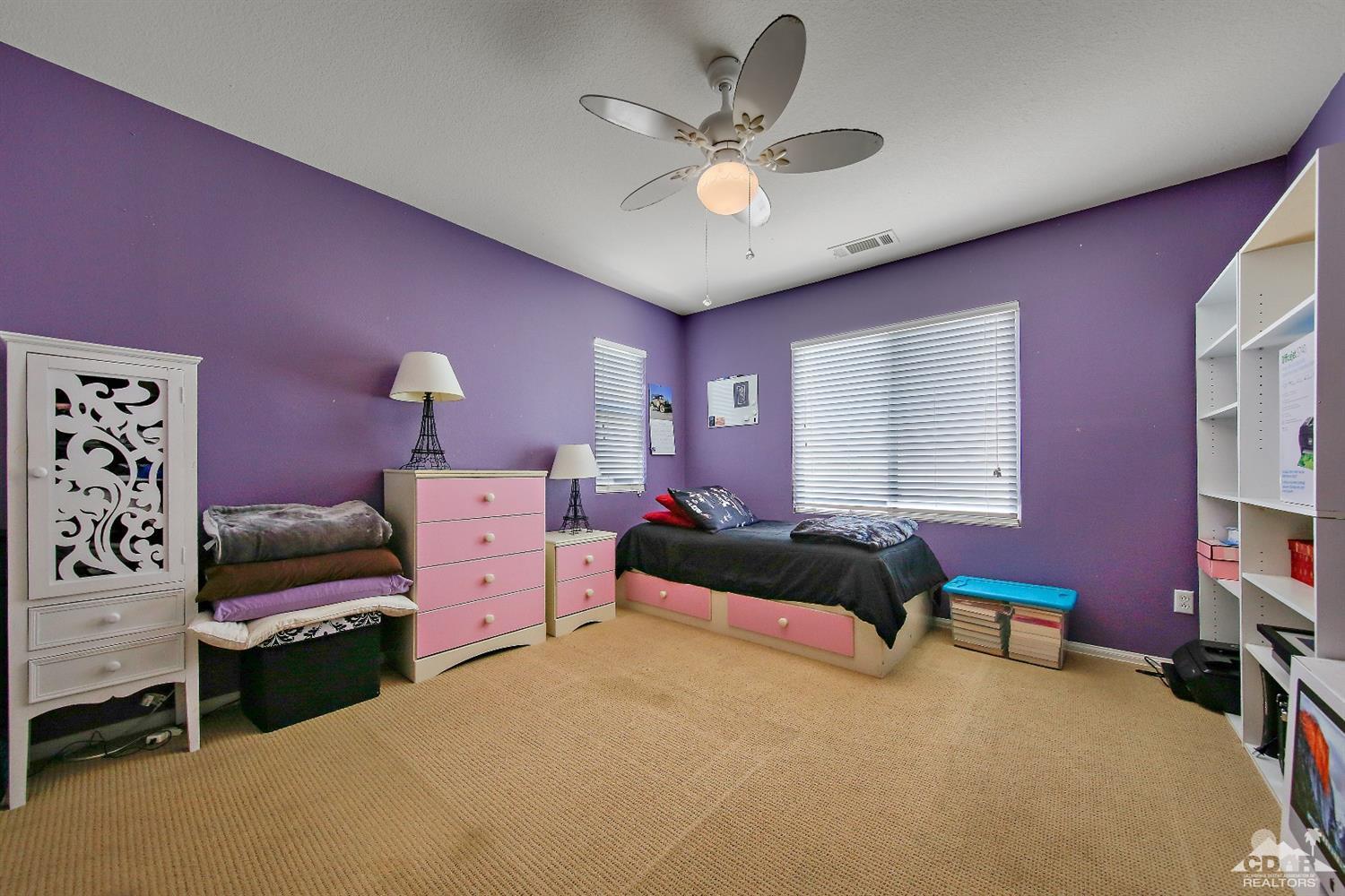 82734 Mount Riley Drive Indio, CA 92203 - Photo 18 of 26 a bedroom with a bed and a chandelier