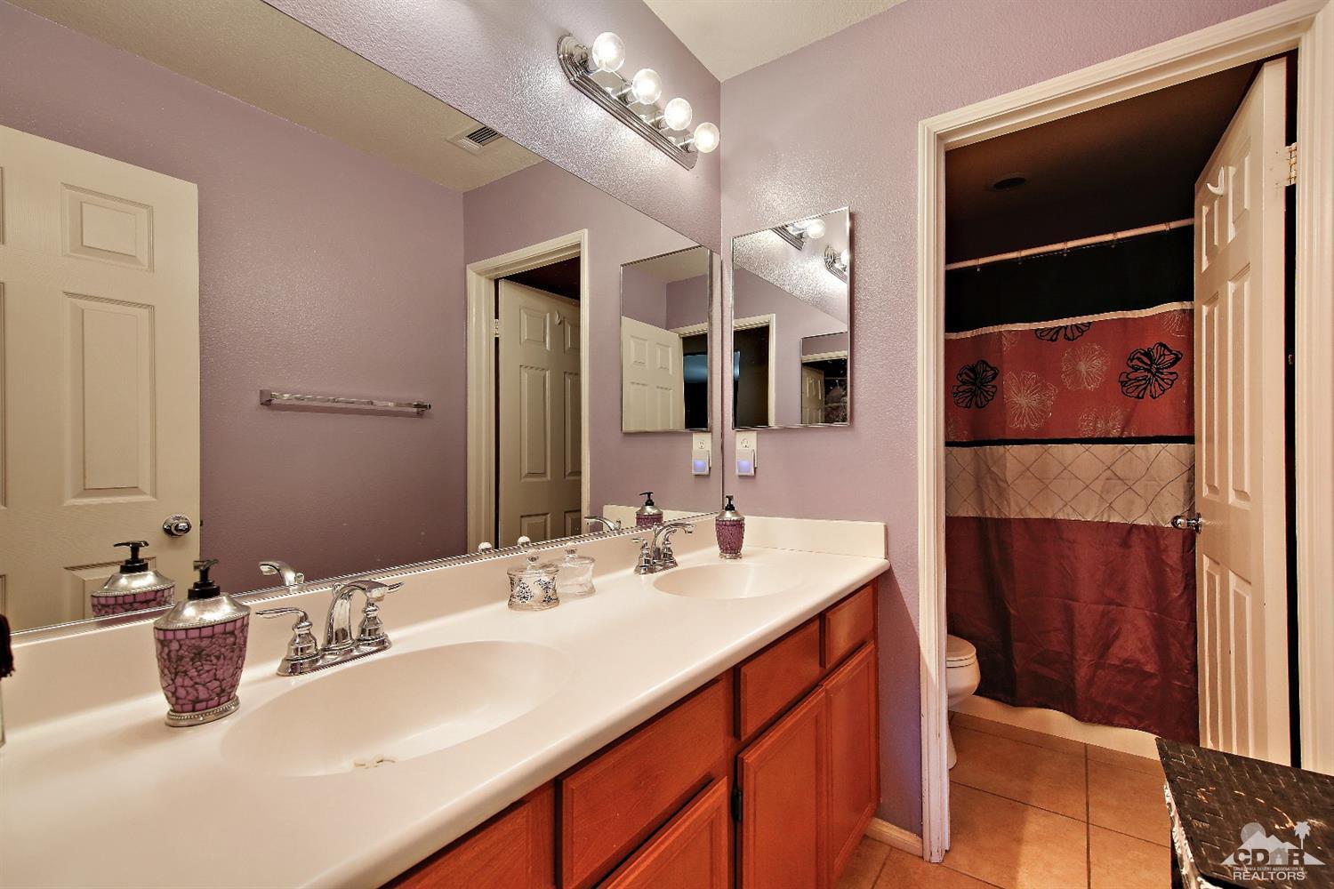 82734 Mount Riley Drive Indio, CA 92203 - Photo 19 of 26 a bathroom with a sink double vanity and a mirror