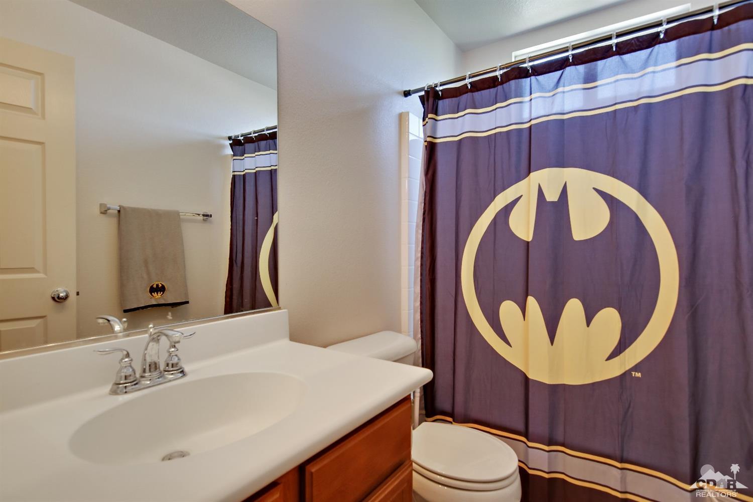 82734 Mount Riley Drive Indio, CA 92203 - Photo 21 of 26 a bathroom with a toilet a sink and a mirror