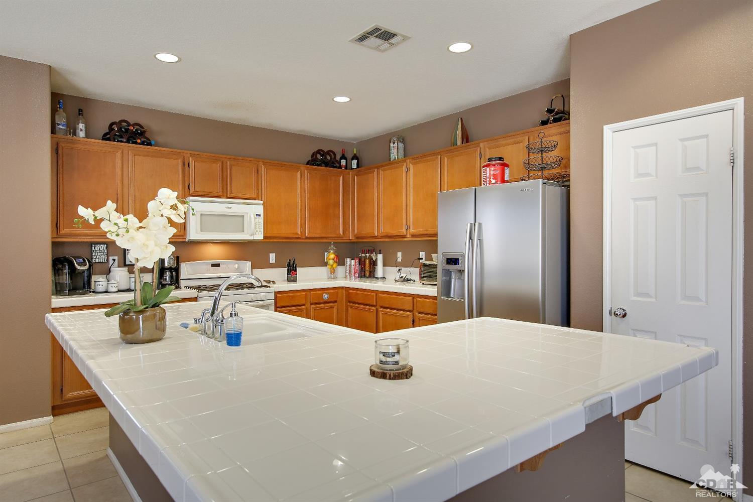 82734 Mount Riley Drive Indio, CA 92203 - Photo 7 of 26 a kitchen with stainless steel appliances a sink and a refrigerator