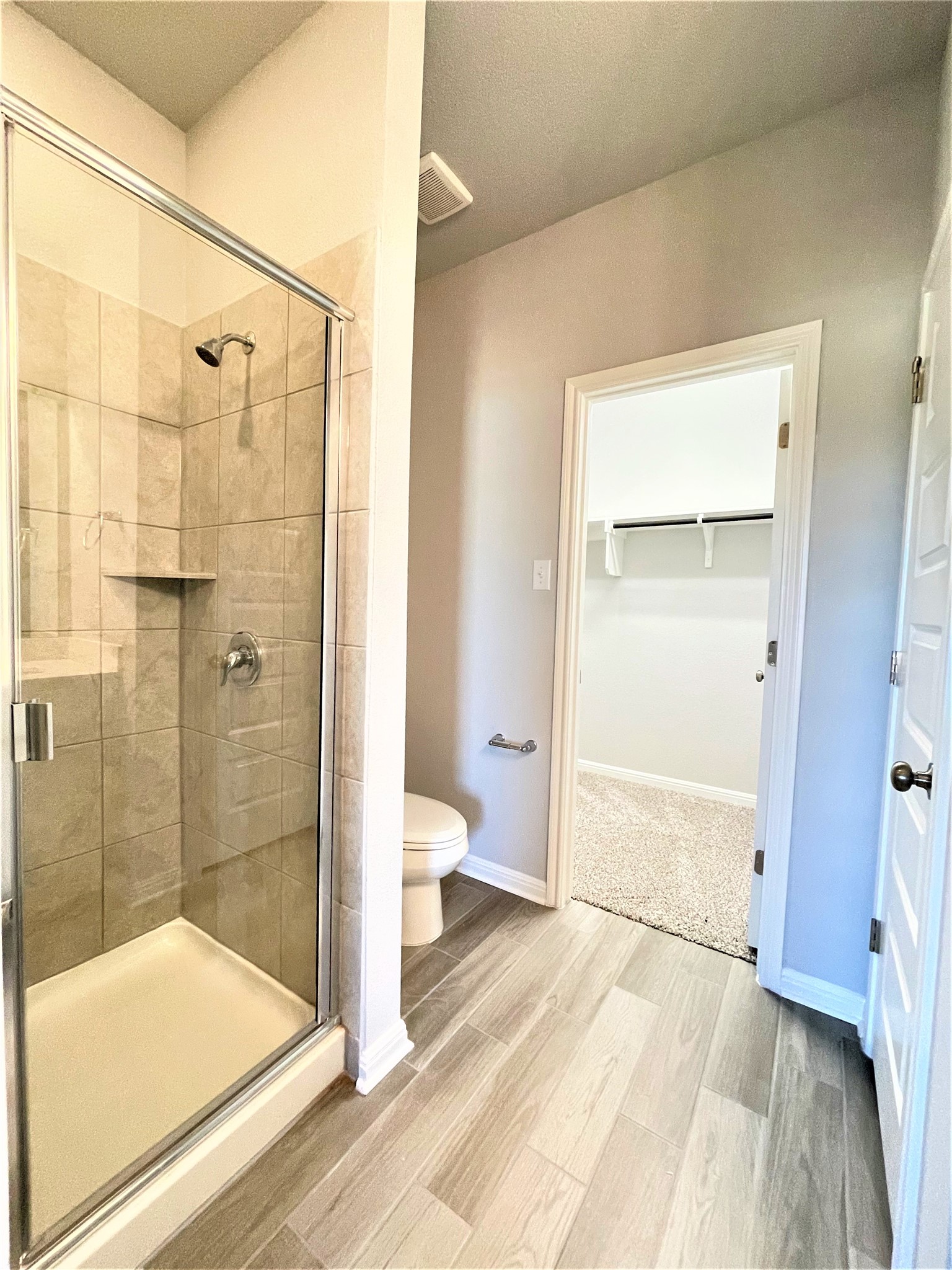 152 Old Stagecoach Road Jarrell, TX 76537 - Photo 11 of 21 Full bathroom featuring a walk in closet, a shower stall, and light wood-type flooring