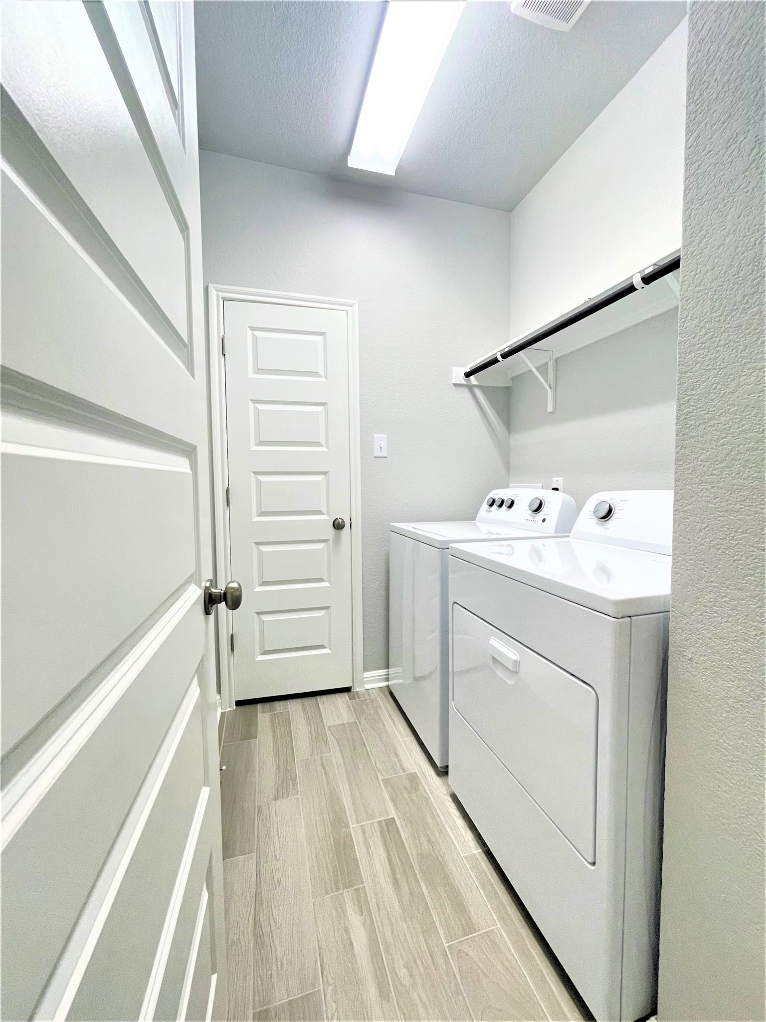 152 Old Stagecoach Road Jarrell, TX 76537 - Photo 12 of 21 Laundry area featuring wood finish floors, washing machine and dryer, and a textured ceiling