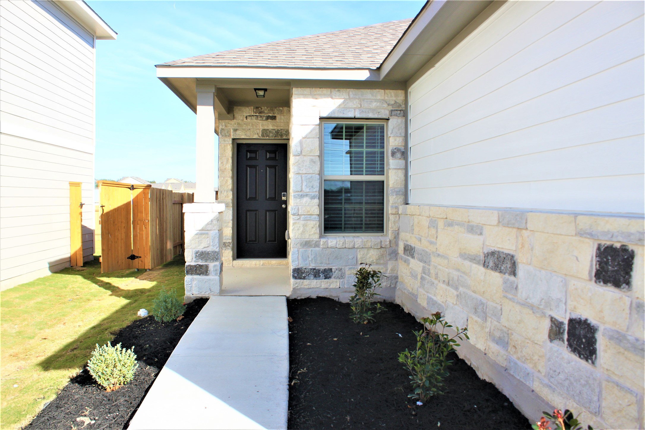 152 Old Stagecoach Road Jarrell, TX 76537 - Photo 3 of 21 View of exterior entry featuring stone siding and roof with shingles
