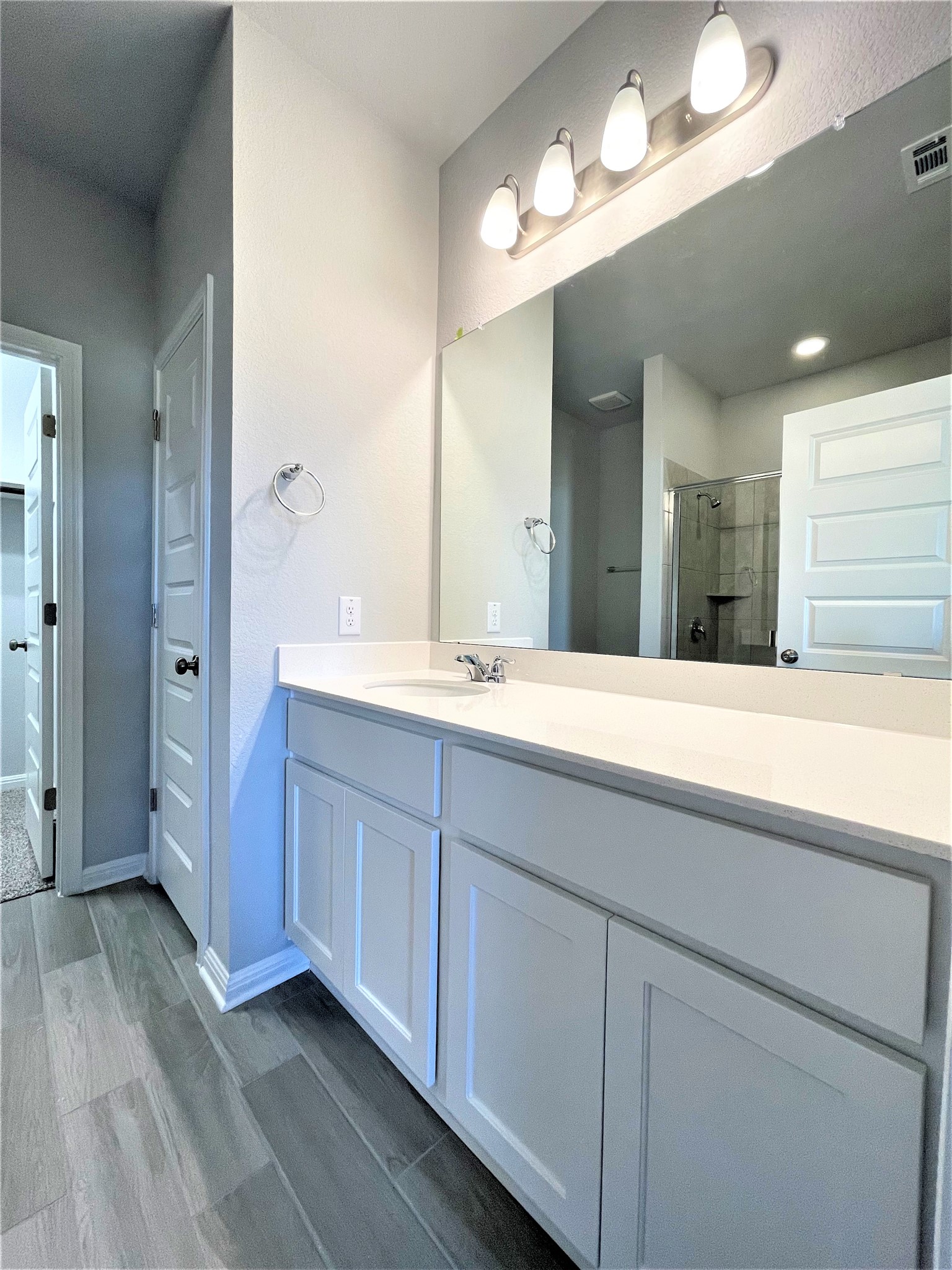 152 Old Stagecoach Road Jarrell, TX 76537 - Photo 10 of 21 Full bathroom featuring vanity, a stall shower, dark wood-style floors, and a closet