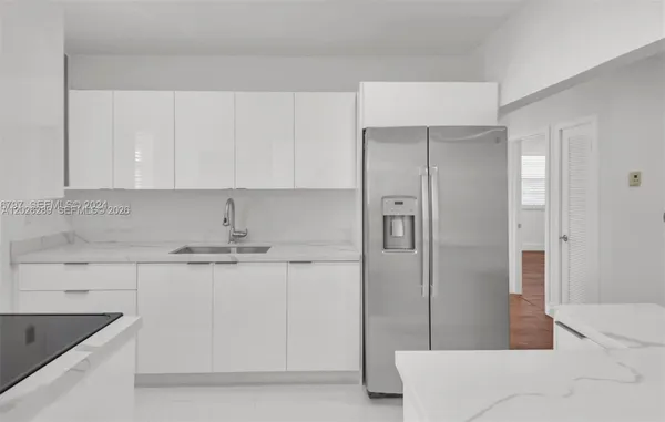 a kitchen with stainless steel appliances granite countertop a refrigerator and a sink