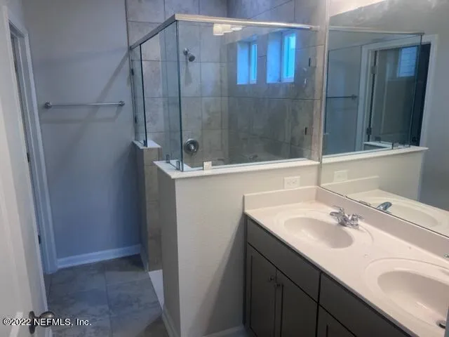 a bathroom with a sink a mirror and a shower