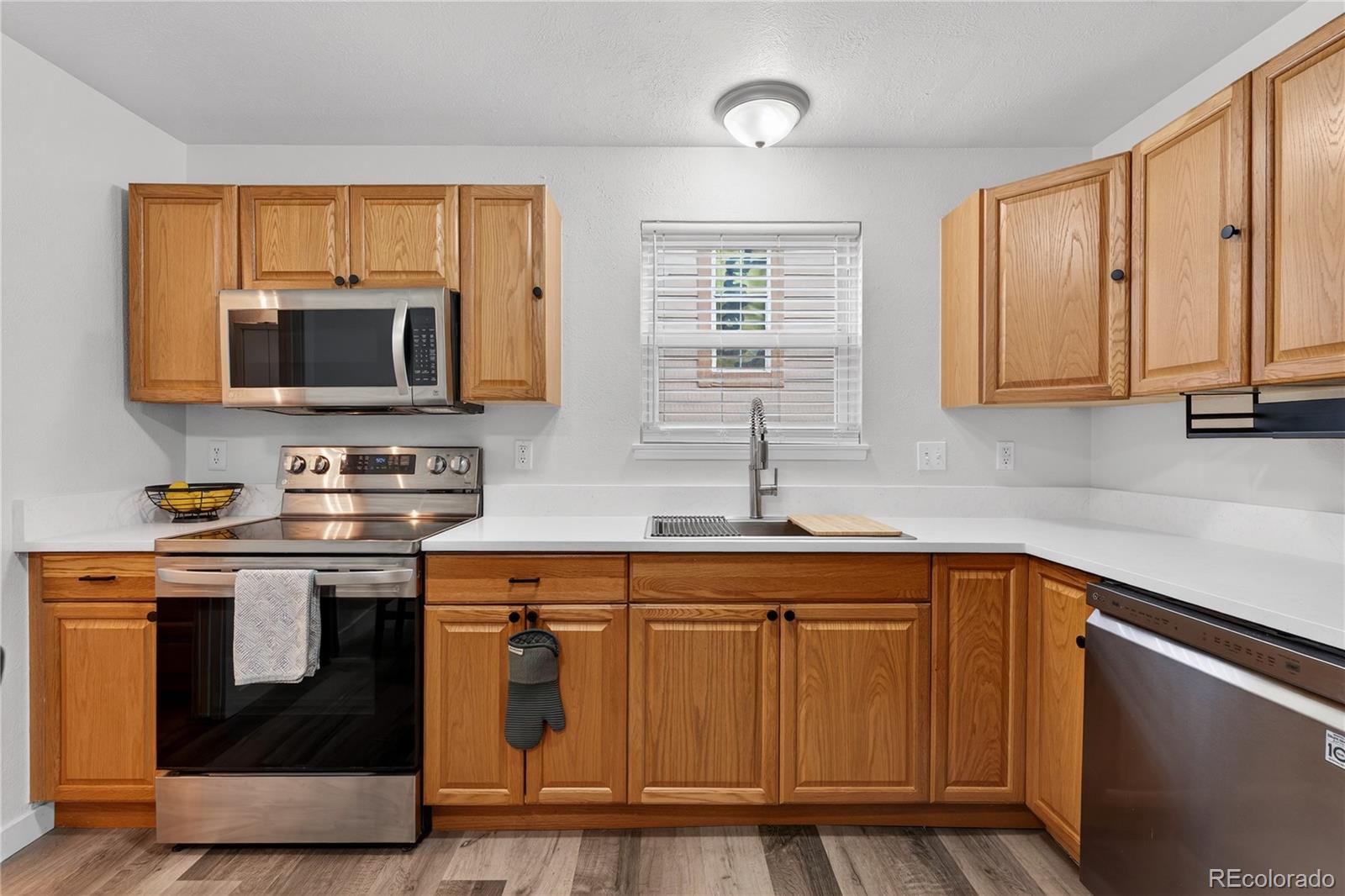 4730 Granby Way Denver, CO 80239 - Photo 11 of 27 a kitchen with stainless steel appliances granite countertop a stove a sink and a microwave