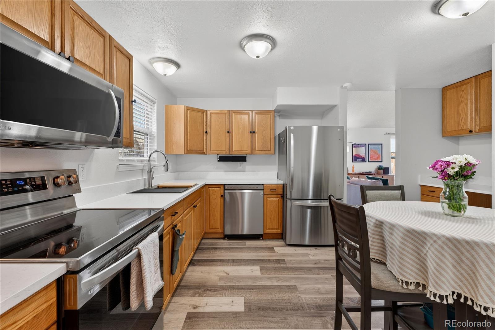 4730 Granby Way Denver, CO 80239 - Photo 12 of 27 a kitchen with stainless steel appliances granite countertop a sink stove and refrigerator