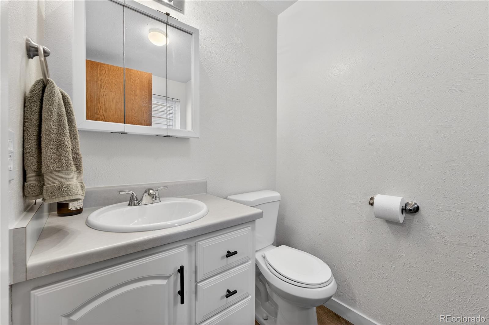 4730 Granby Way Denver, CO 80239 - Photo 14 of 27 a bathroom with a toilet sink and mirror