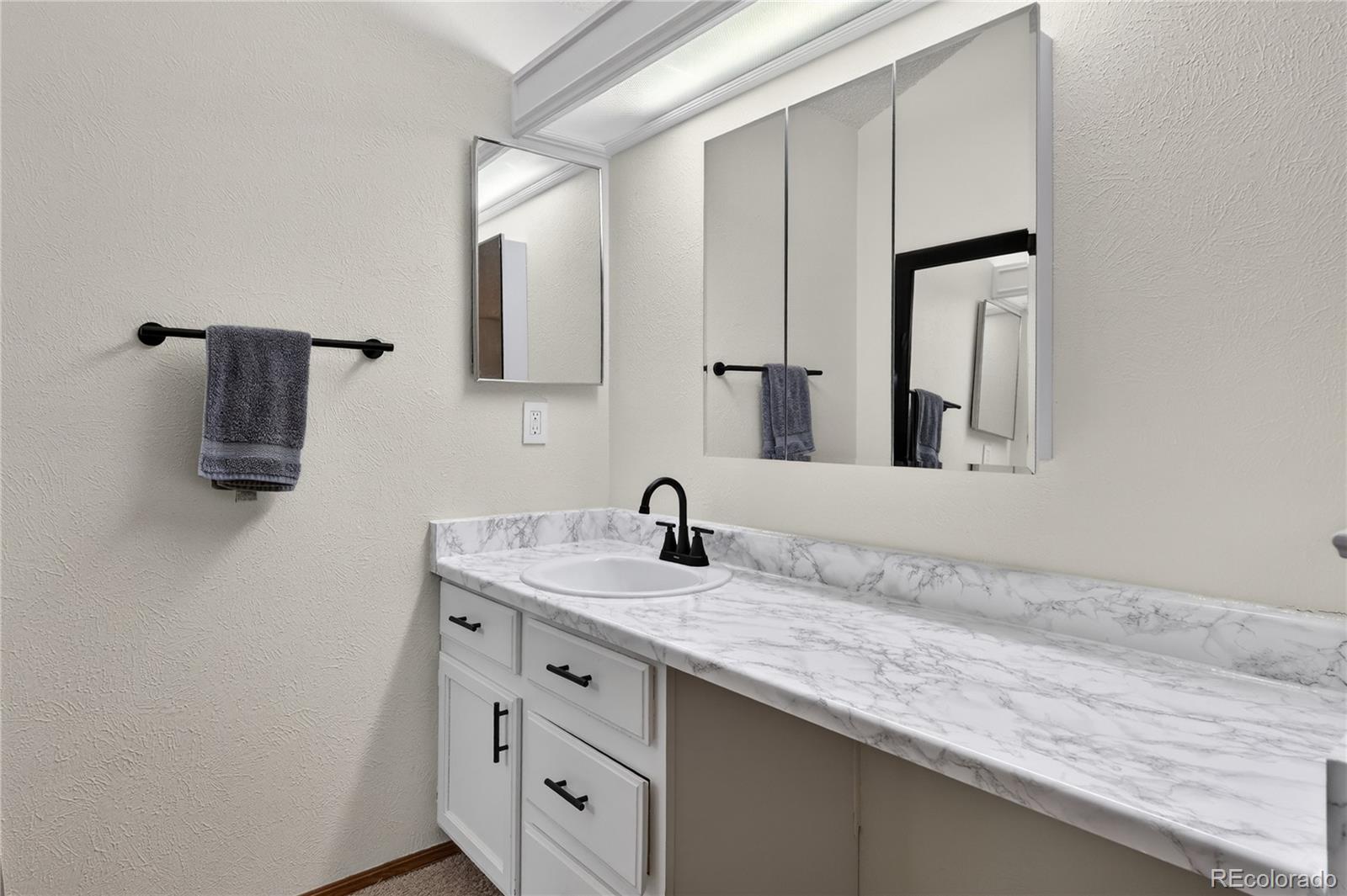 4730 Granby Way Denver, CO 80239 - Photo 18 of 27 a bathroom with a granite countertop sink and a mirror