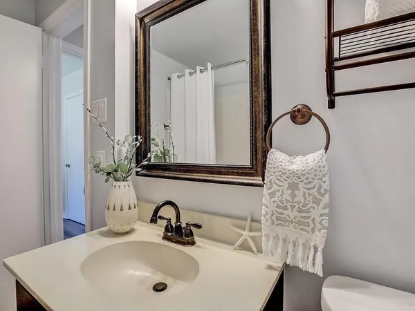 a view of a backyard with table and chairs potted plants and a large tree