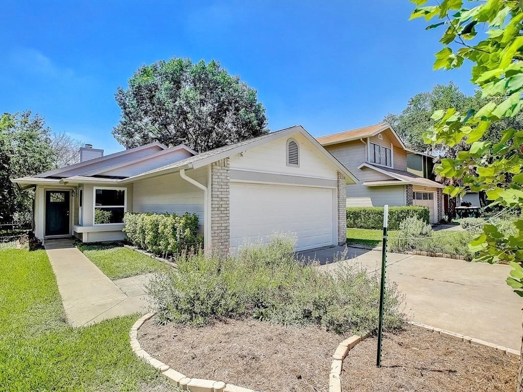 12909 Modena Trail Austin, TX 78729 - Photo 2 of 26 a view of a house with a yard and a garden