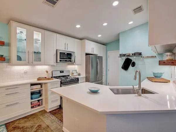 a kitchen with a sink appliances and cabinets