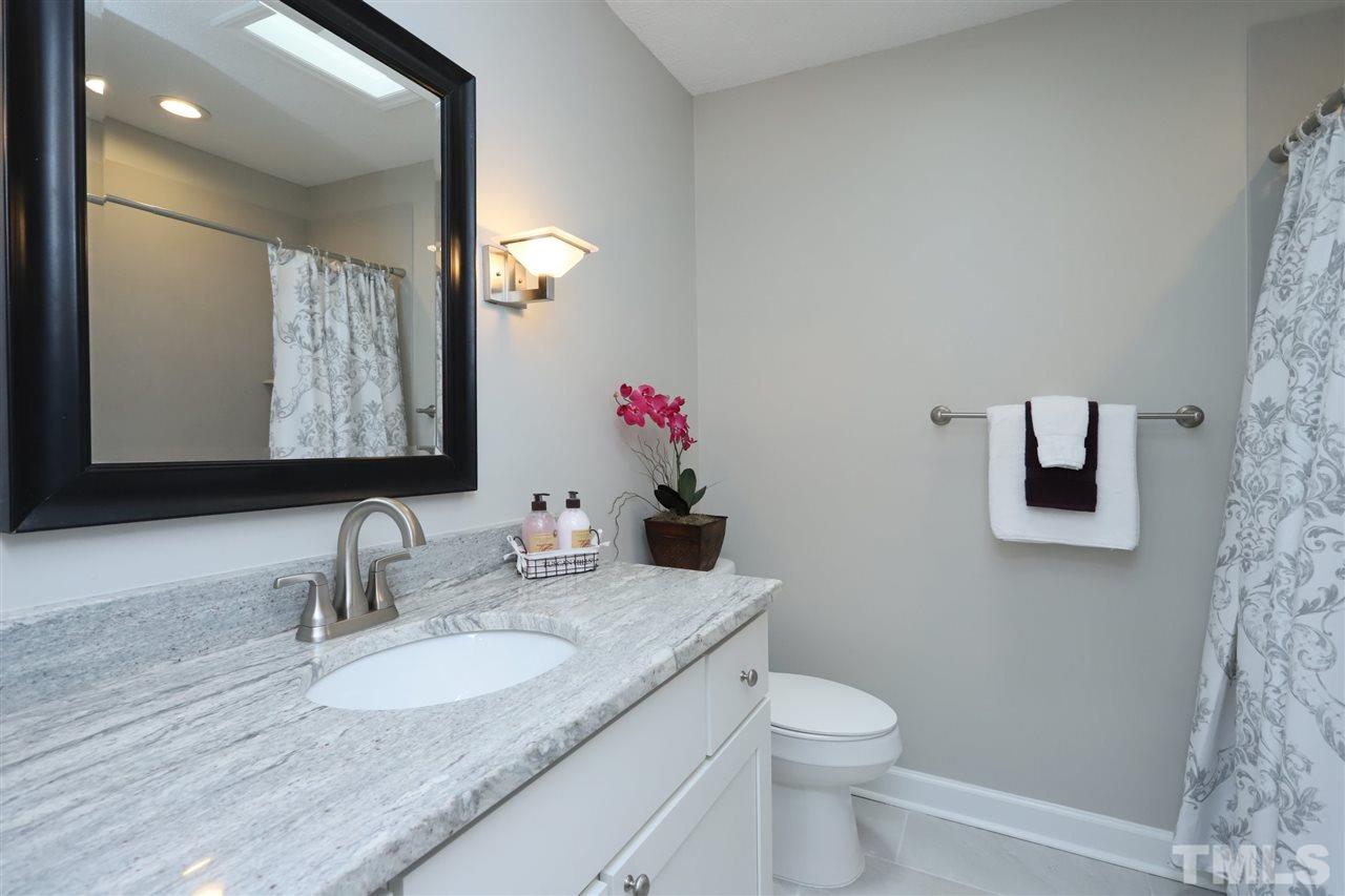 4101 Stranaver Place Raleigh, NC 27612 - Photo 21 of 27 Hall bath has been updated with granite vanity top and ceramic tub surround.
